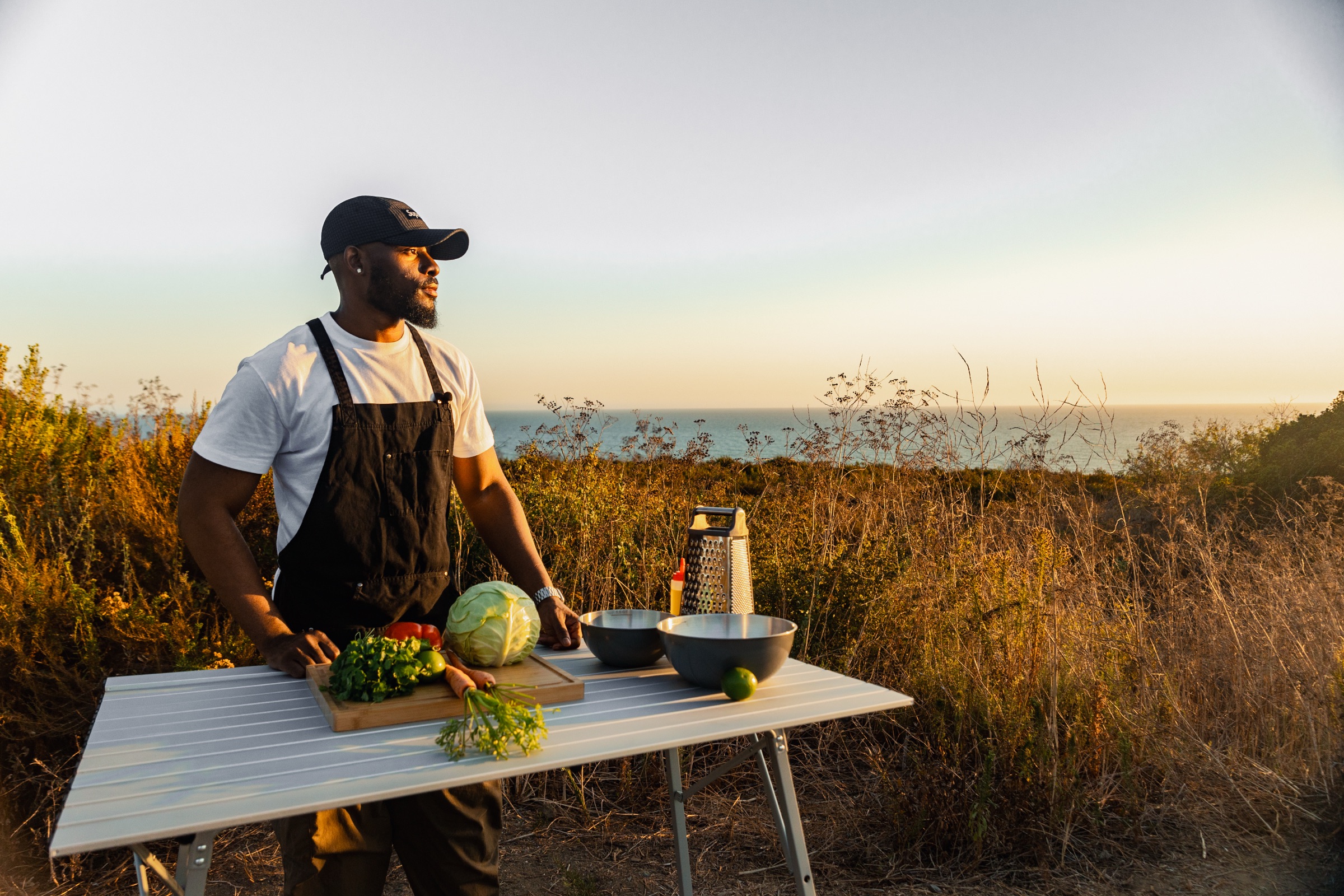 Davon at his field kitchen table above the coast at golden hour