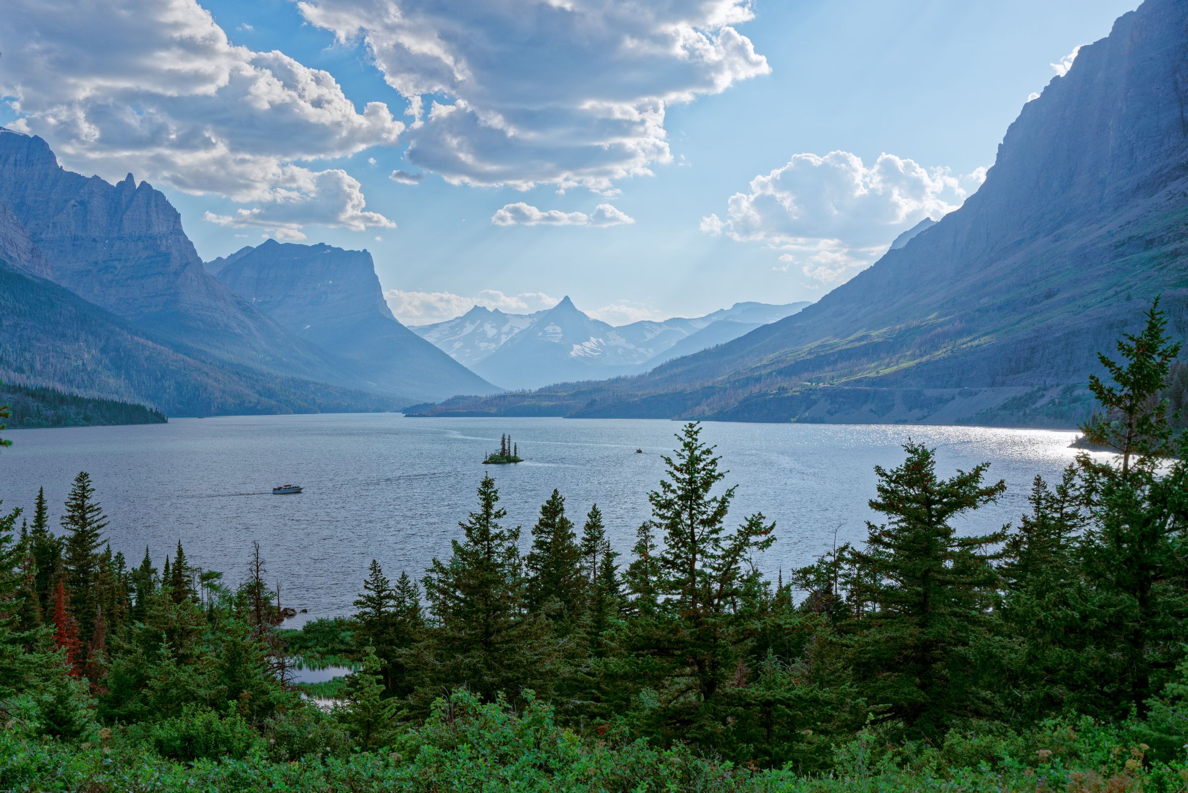 A glacial lake framed by steep peaks and pines in Glacier National Park